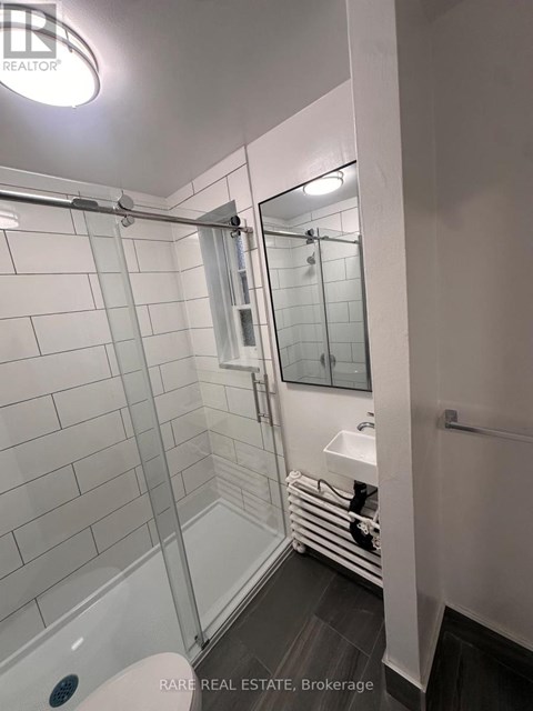 A white tiled bathroom with a walk-in shower.