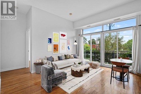 A living room with a white couch, a coffee table, and a painting on the wall.