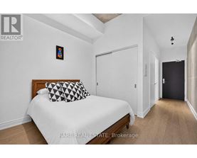 A bedroom with a bed, a pillow, and a picture on the wall.