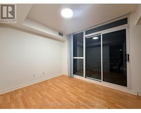 A room with a sliding glass door and wooden flooring.