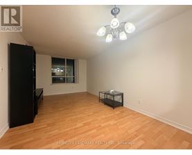 A room with wooden flooring and a black cabinet.