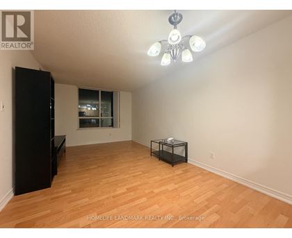 A room with wooden flooring and a black cabinet.