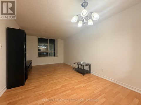 A room with wooden flooring and a black cabinet.
