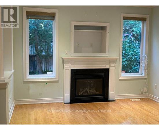 A room with a fireplace and two windows.