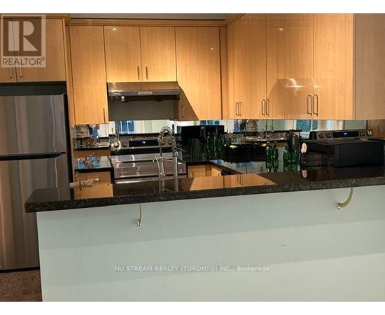 A kitchen with a countertop that has a brokerage sign on it.