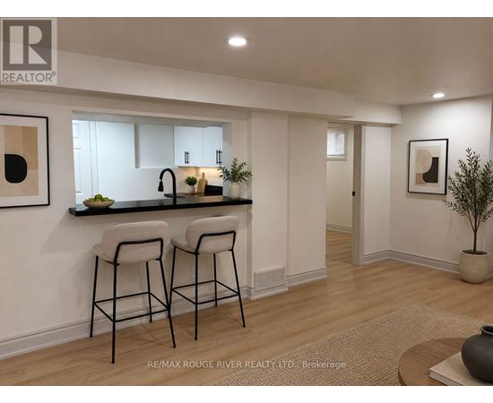 A modern kitchen with a bar stool and a plant.