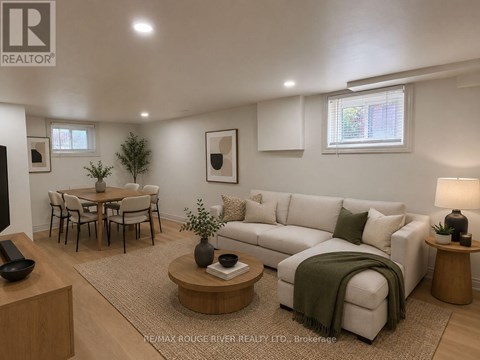 A living room with a couch, coffee table, and a dining table.