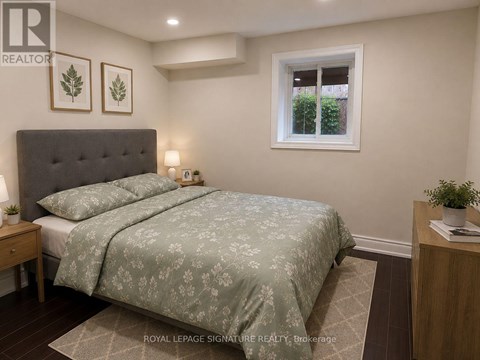 A bedroom with a bed, nightstand, and window.
