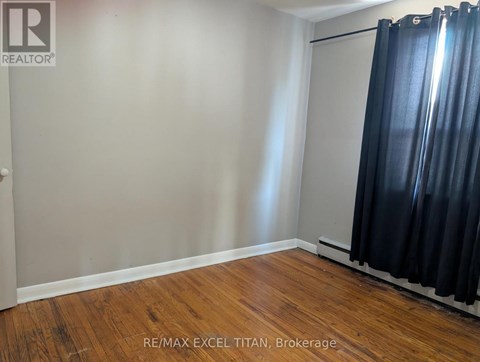 A room with a sliding door and wooden flooring.