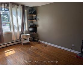 A room with a desk and a window with curtains.