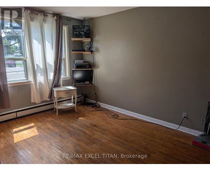 A room with a desk and a window with curtains.