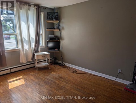 A room with a desk and a window with curtains.