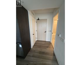 A hallway with a washer and dryer in the corner.