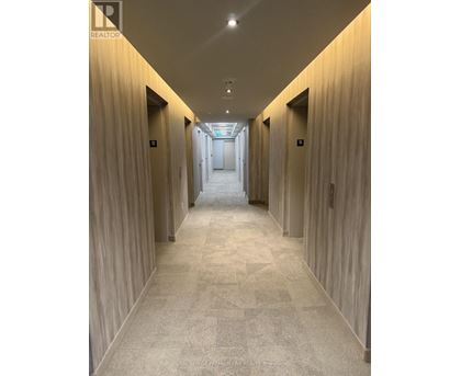 A long hallway with doors on both sides and a carpeted floor.