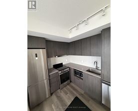 A modern kitchen with stainless steel appliances and wooden cabinets.