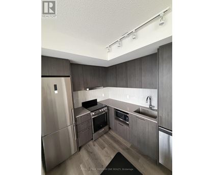 A modern kitchen with stainless steel appliances and wooden cabinets.