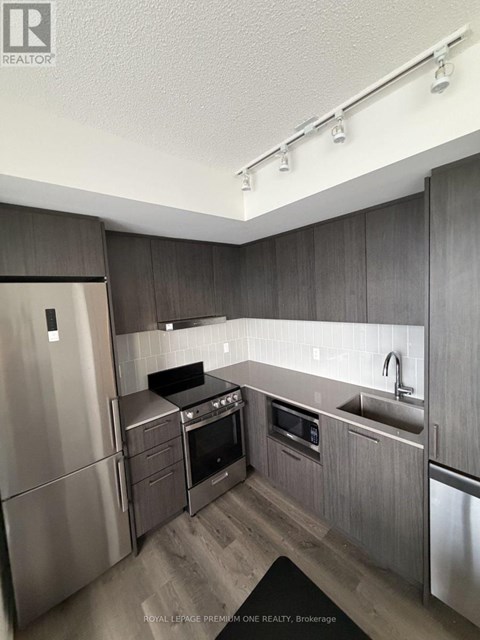 A modern kitchen with stainless steel appliances and wooden cabinets.