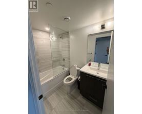 A bathroom with a toilet, sink, and shower.