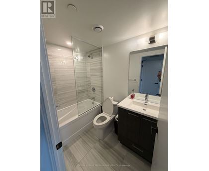 A bathroom with a toilet, sink, and shower.