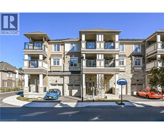 A blue car is parked in front of a two-story apartment building.