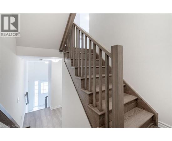A wooden staircase leads up to a bright room.