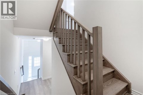 A wooden staircase leads up to a bright room.