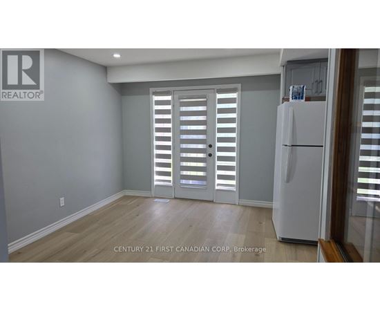 A room with a white refrigerator and a sliding door with shutters.