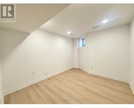 A room with wooden flooring and white walls.