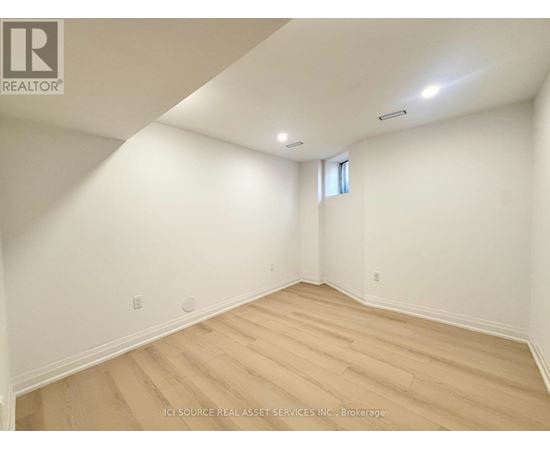 A room with wooden flooring and white walls.