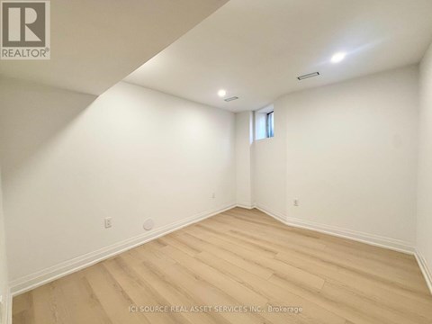 A room with wooden flooring and white walls.