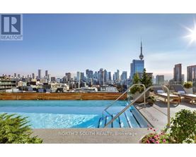 A pool with a slide and a view of the city skyline in the background.