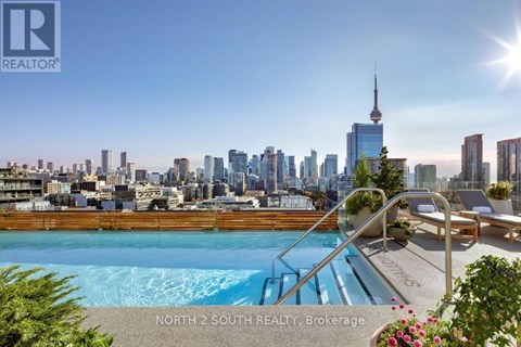 A pool with a slide and a view of the city skyline in the background.