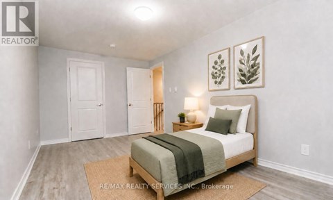 A bedroom with a bed, two nightstands, and a rug.