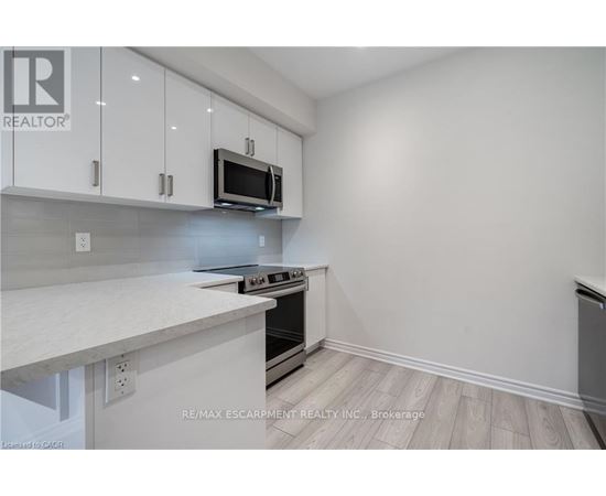A kitchen with white cabinets and a microwave above the stove.