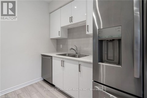 A modern kitchen with white cabinets and stainless steel appliances.