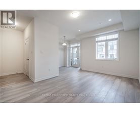 A spacious room with wooden flooring and white walls.