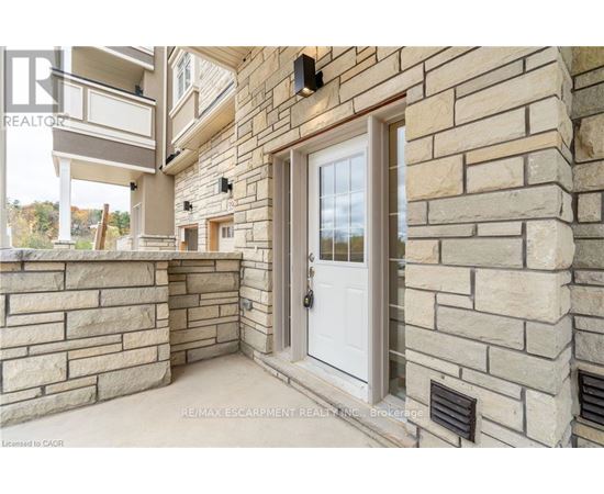 A stone wall with a white door and window.