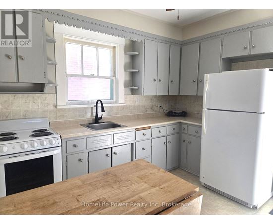 A kitchen with a white refrigerator, white cabinets, and a white stove.