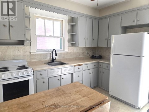 A kitchen with a white refrigerator, white cabinets, and a white stove.
