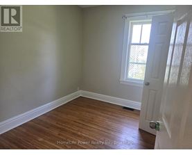 A room with wooden flooring and a white door.