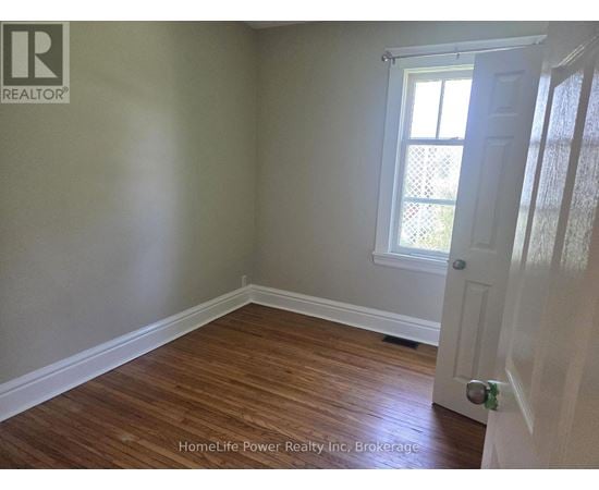 A room with wooden flooring and a white door.