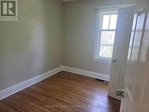 A room with wooden flooring and a white door.