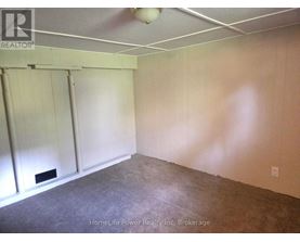 A room with a carpeted floor and a white ceiling with a light fixture.