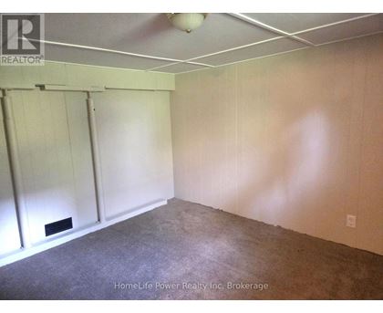 A room with a carpeted floor and a white ceiling with a light fixture.