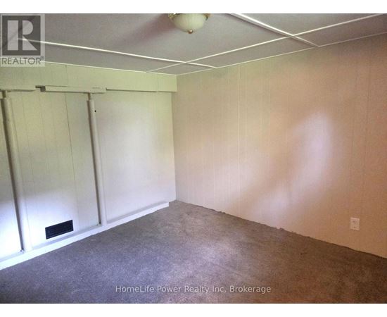 A room with a carpeted floor and a white ceiling with a light fixture.