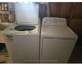 A white dryer and washer are sitting next to each other.