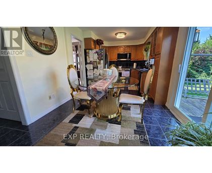 A kitchen with a dining table and chairs in the middle of the room.