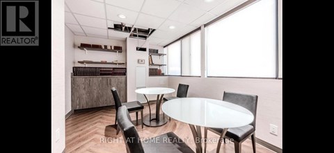 A dining room with a table and chairs.
