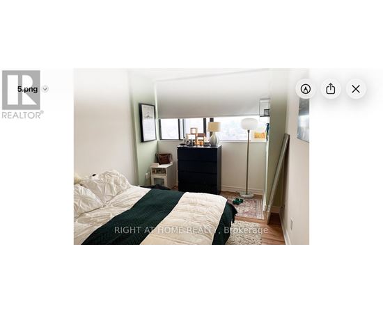 A bedroom with a bed, nightstand, and a window.