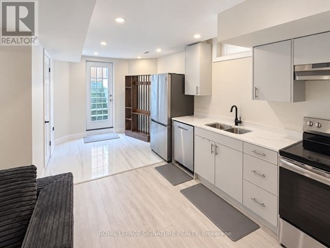 A modern kitchen with white cabinets and stainless steel appliances.